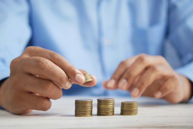 A pair of hands stacking some coins.